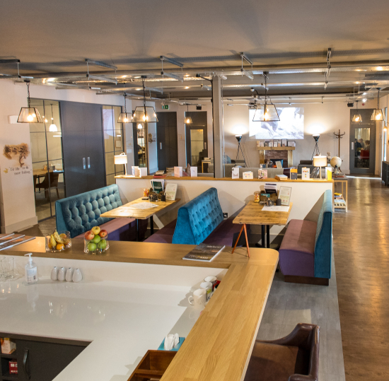 Joslin Rhodes - Interior of Joslin Rhodes office lounge area featuring booths and sofas arranged to create a warm, welcoming atmosphere.