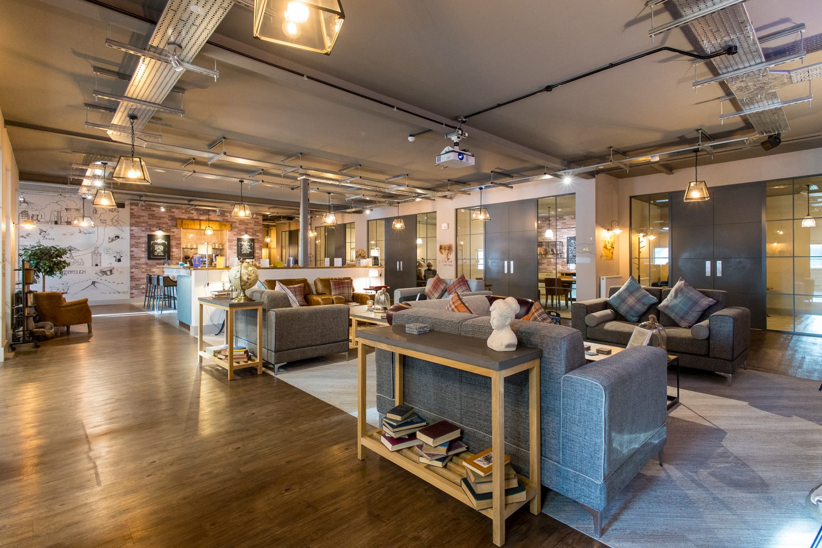 Joslin Rhodes - Interior of the Joslin Rhodes office featuring a cosy lounge area, bistro, and kitchen, with warm lighting and comfortable sofas creating a welcoming atmosphere.