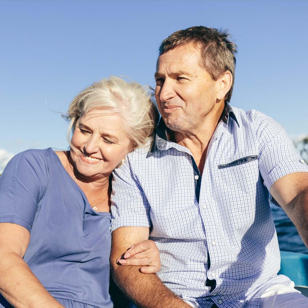 Joslin Rhodes - Retired couple smiling and enjoying a boat trip together.