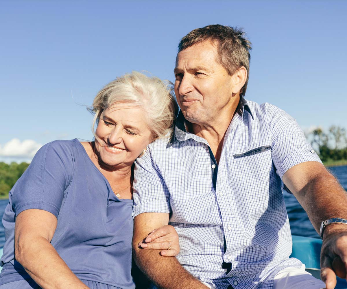 Joslin Rhodes - Retired couple smiling and enjoying a boat trip together.