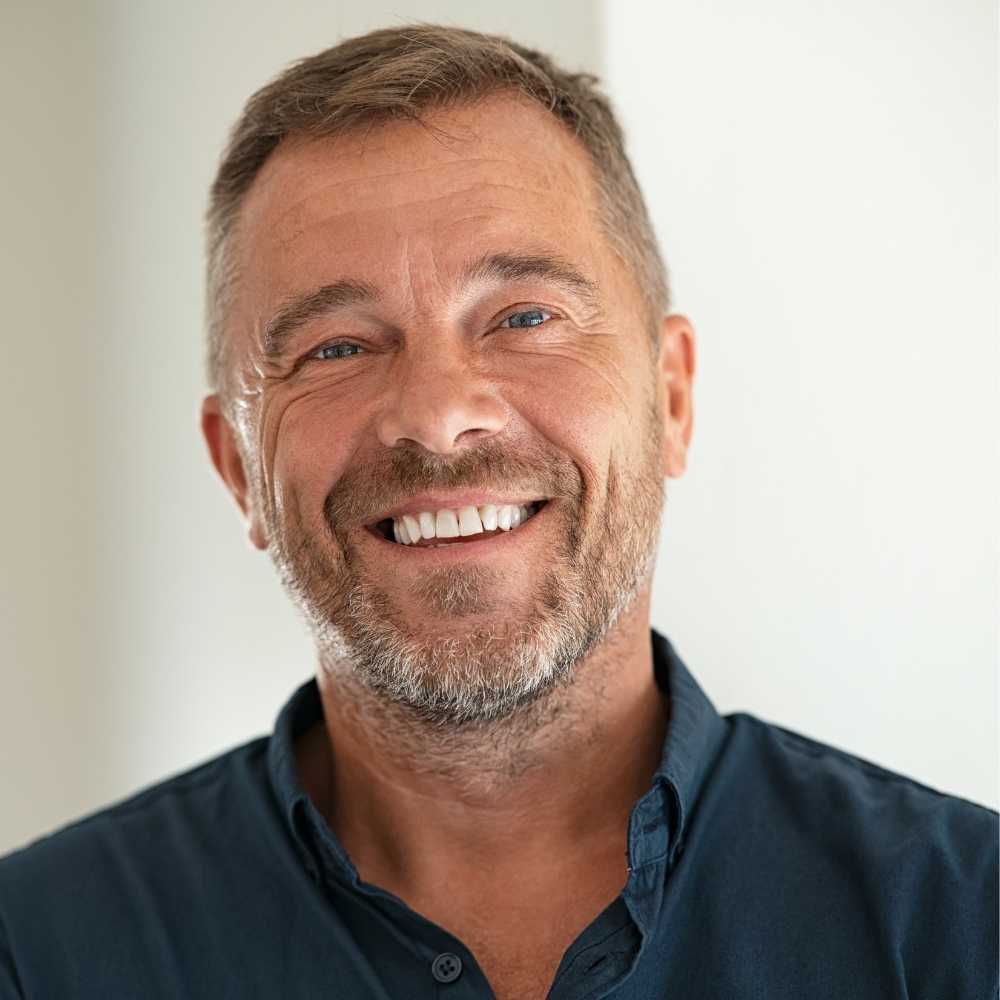 Joslin Rhodes - Smiling middle-aged man wearing a black shirt against a plain background.