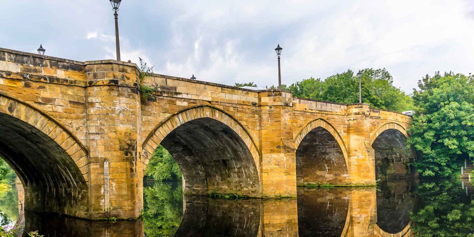 Joslin Rhodes - Yarm Bridge with a cloudy sky in the background and the river flowing beneath.
